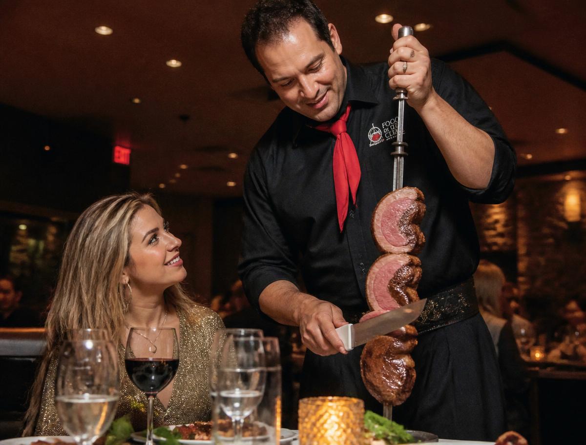 Empregado a cortar carne do espeto junto à mesa em serviço de rodízio